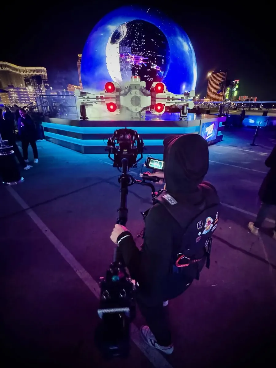 Michael Deitch operating toward the LEGO Star Wars X-wing display with Sphere behind it at night